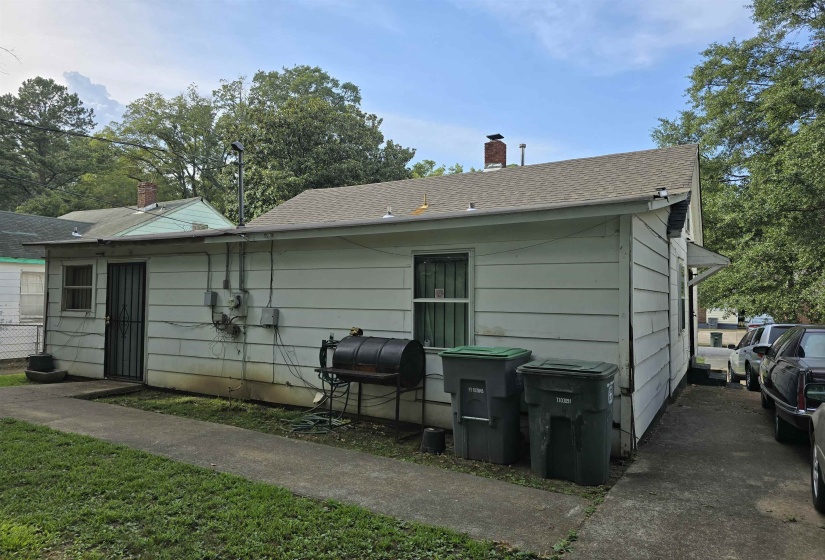 Rear view of house featuring roof with shingles and a chimney