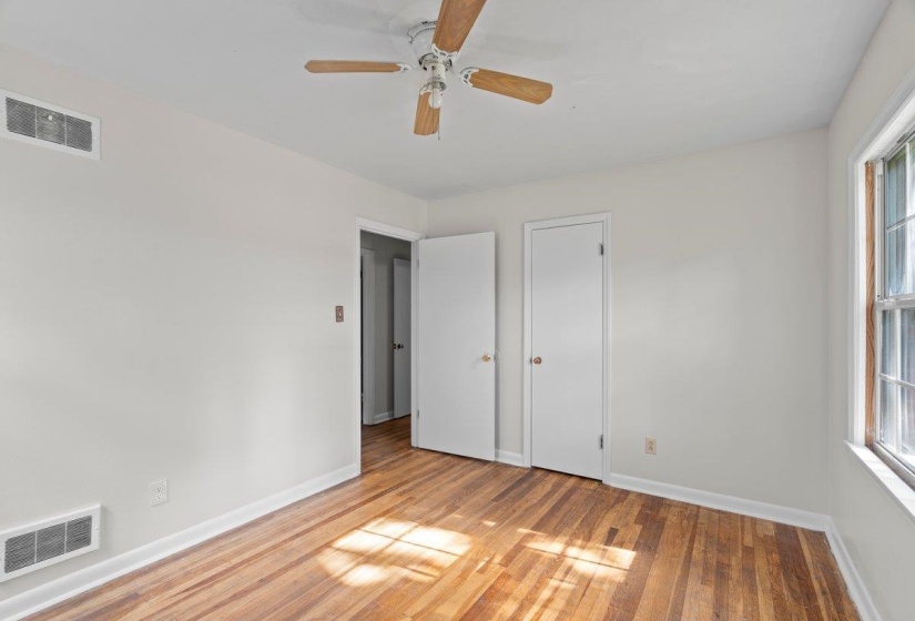 Unfurnished bedroom featuring wood finished floors and ceiling fan