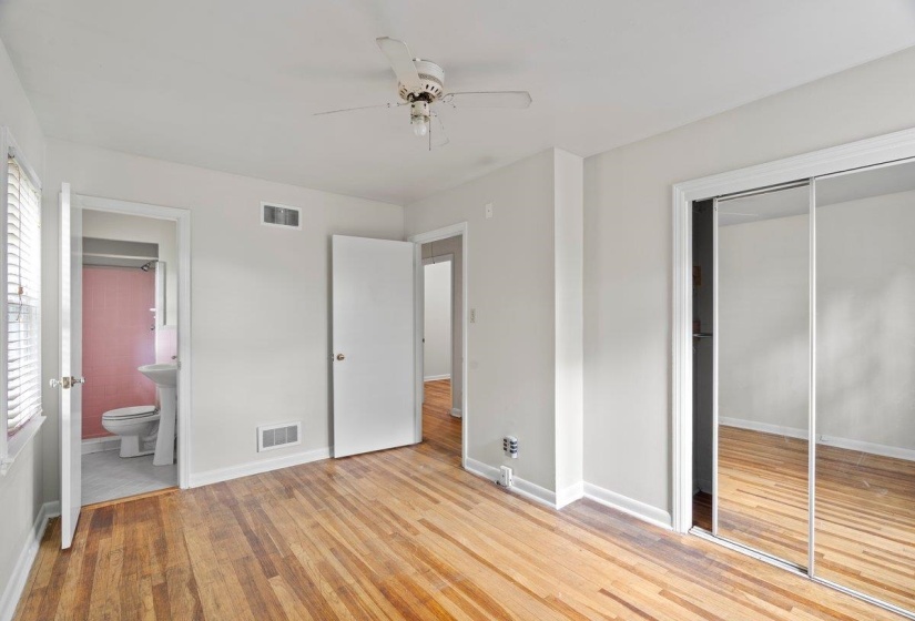 Unfurnished bedroom featuring light wood finished floors, ceiling fan, a closet, and ensuite bath