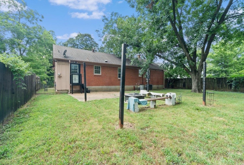 Rear view of house with a patio area, a fenced backyard, and brick siding
