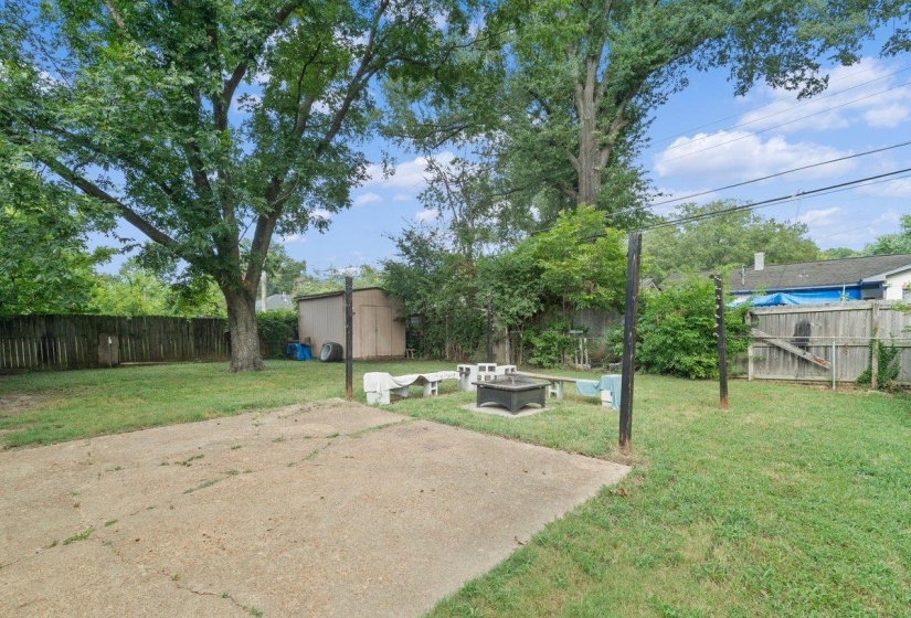 Fenced backyard with a patio area, an outdoor fire pit, and a storage unit