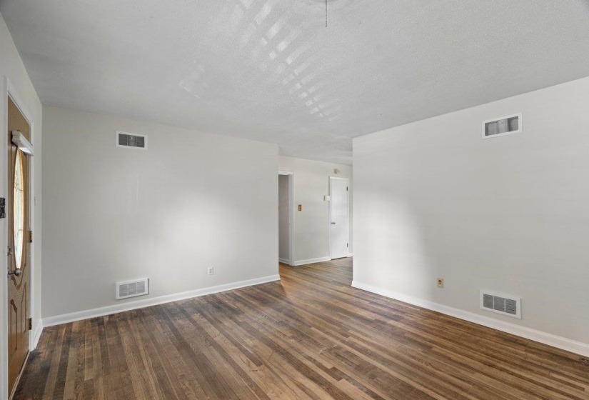 Unfurnished room with dark wood finished floors and a textured ceiling