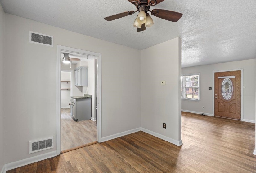 Empty room with light wood-style flooring, a textured ceiling, and ceiling fan