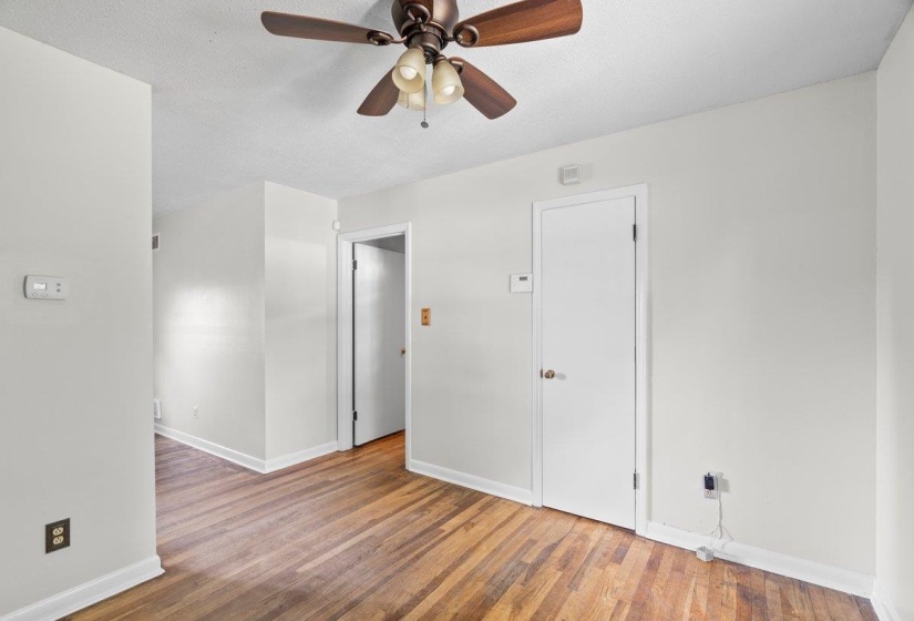Spare room with wood finished floors, ceiling fan, and a textured ceiling