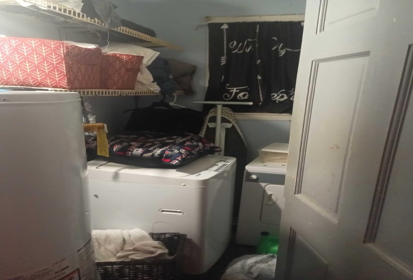 Washroom featuring water heater and washer and clothes dryer