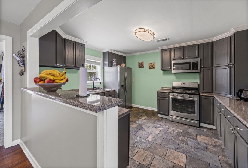 Kitchen featuring appliances with stainless steel finishes, ornamental molding