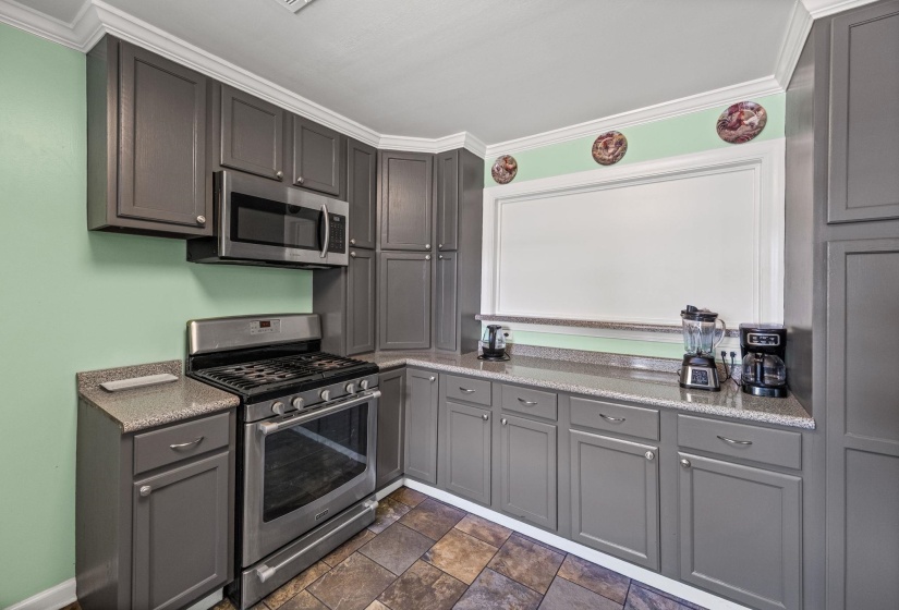 Kitchen featuring stainless steel appliances, ornamental molding, gray cabinets