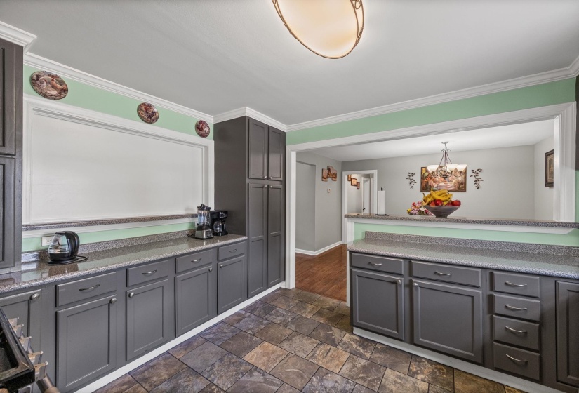 Kitchen with gray cabinets, crown molding, dark tile finish floors