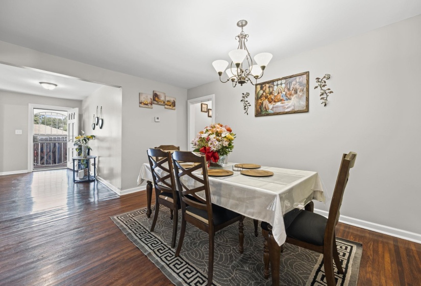 Dining space featuring dark wood-style floors and a chandelier