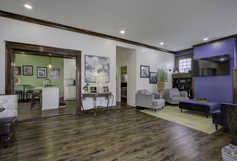 Living area with crown molding, dark wood-style floors, and recessed lighting