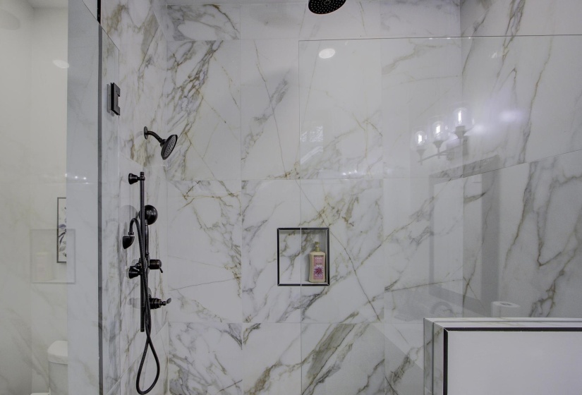 Bathroom featuring a marble finish shower and toilet