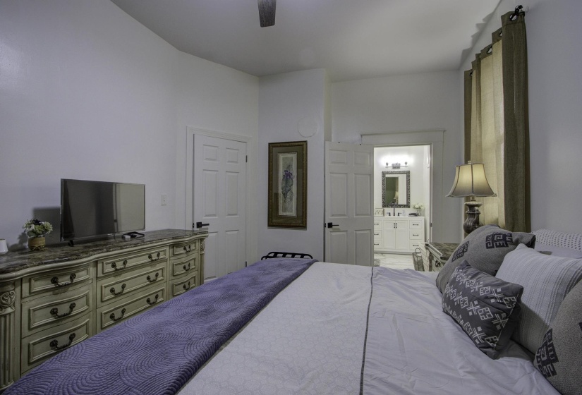 Bedroom with a ceiling fan and connected bathroom