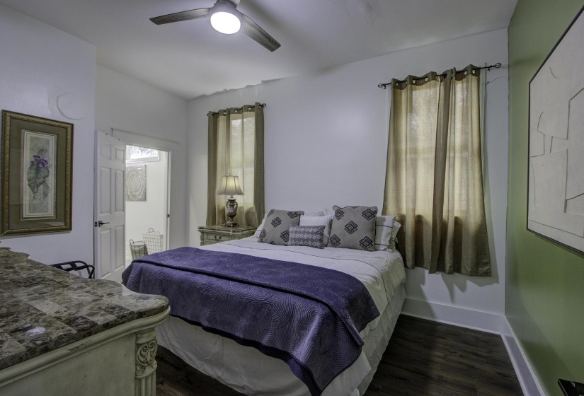 Bedroom with dark wood-type flooring and a ceiling fan