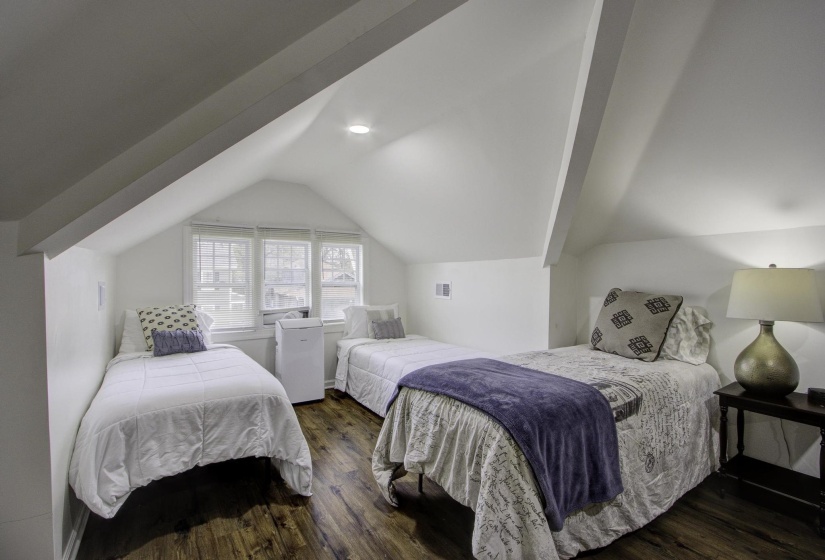 Bedroom featuring dark wood-style flooring and lofted ceiling