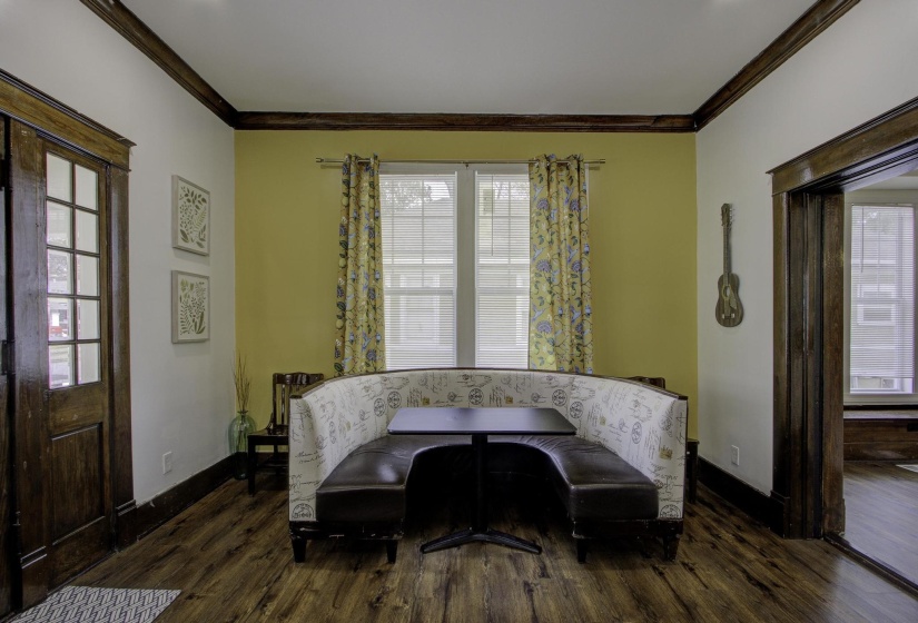 Living area with healthy amount of natural light, crown molding, and dark wood-type flooring