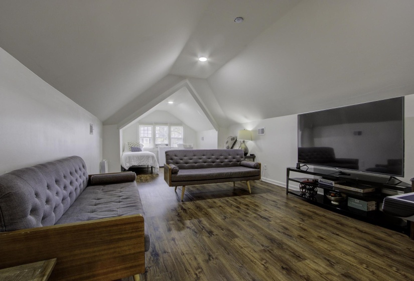 Living area featuring lofted ceiling and dark wood-style flooring