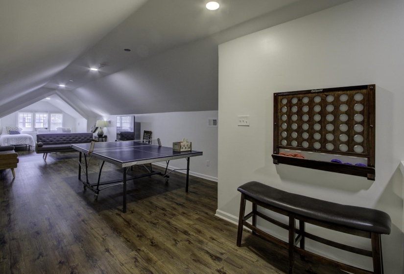 Rec room featuring dark wood-type flooring, vaulted ceiling, and recessed lighting