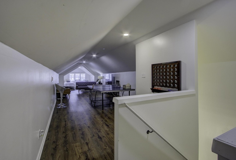Hall featuring dark wood finished floors, vaulted ceiling, and recessed lighting