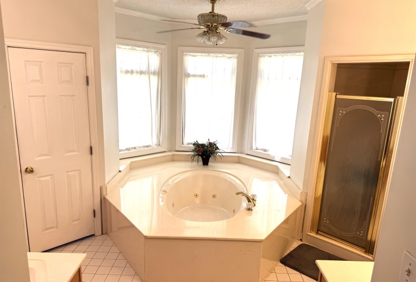 Full bath with a jetted tub, vanity, light tile patterned floors, a stall shower, and a textured ceiling