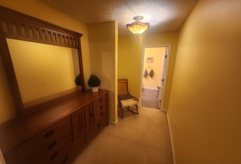 Corridor with a textured ceiling and light carpet