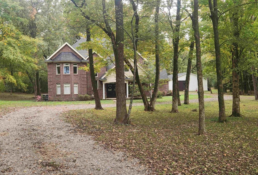 Traditional home with brick siding, driveway, and a front lawn