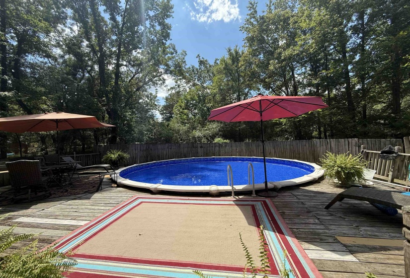 View of swimming pool featuring a wooden deck and a fenced backyard