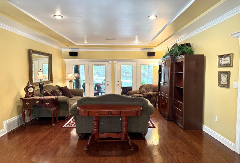 Game room with dark wood-style floors and crown molding