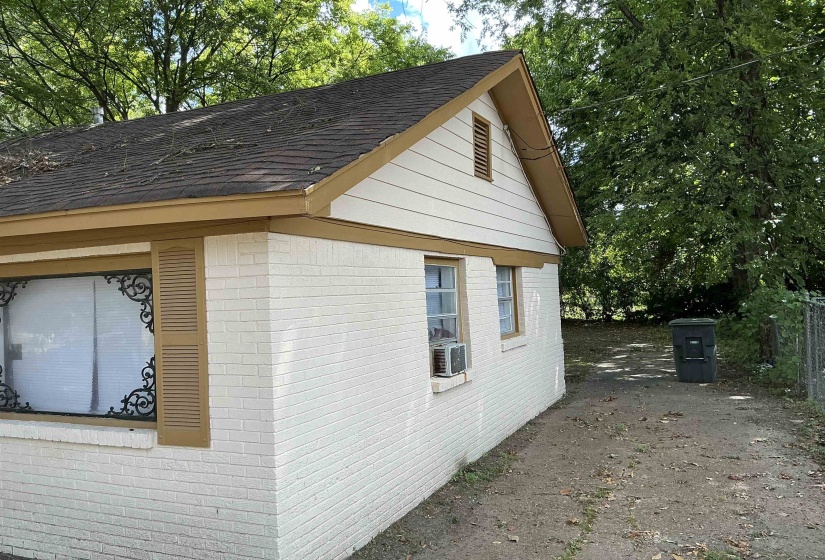 View of side of property featuring brick siding and a shingled roof