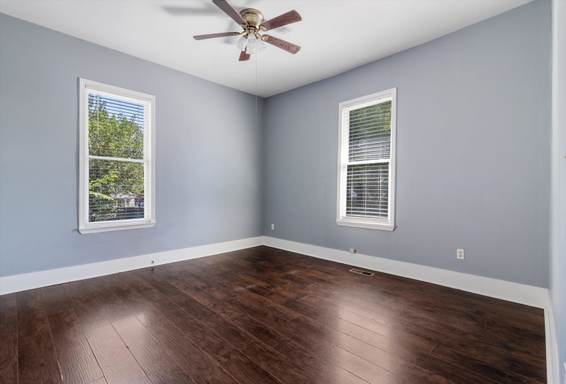 Unfurnished room featuring dark wood-style floors and ceiling fan
