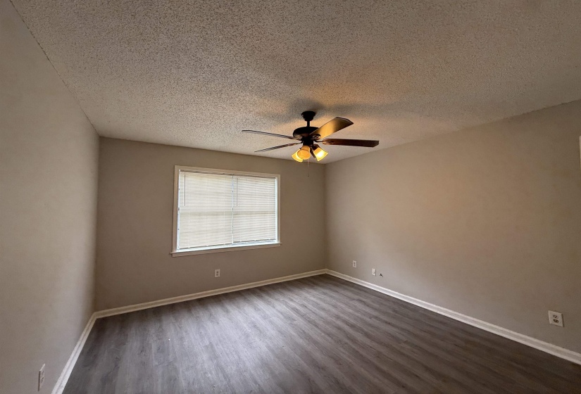 Spare room featuring dark wood finished floors, a textured ceiling, and a ceiling fan