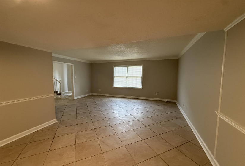 Unfurnished room with light tile patterned floors, ornamental molding, and a textured ceiling