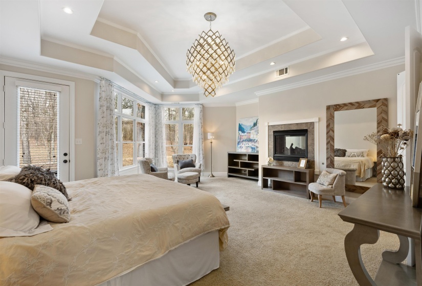 Bedroom featuring carpet flooring, access to outside, a raised ceiling, and crown molding