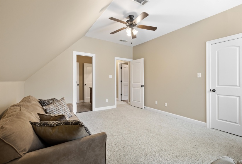 Bedroom 4 or Sitting Room featuring ceiling fan, light colored carpet, and lofted ceiling