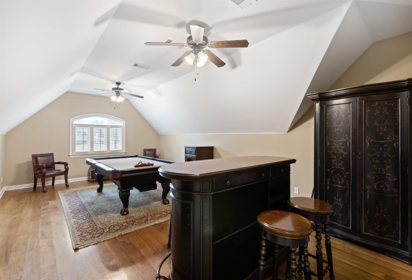 Recreation room featuring light hardwood / wood-style flooring, ceiling fan, lofted ceiling