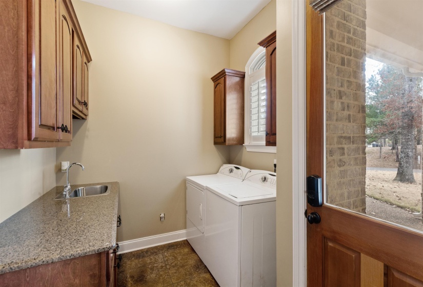 Washroom featuring washer and clothes dryer, sink, and cabinets
