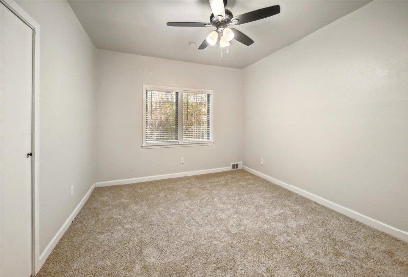 Unfurnished bedroom featuring ceiling fan, light colored carpet, and a closet