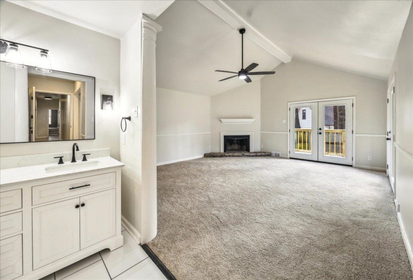 Bathroom featuring french doors, high vaulted ceiling, vanity, ceiling fan, and beam ceiling