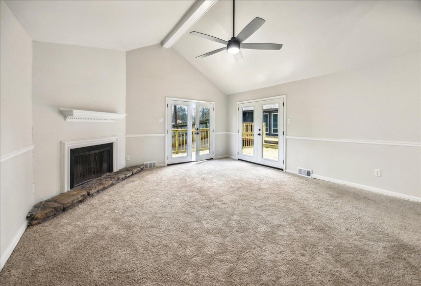Unfurnished master featuring carpet, high vaulted ceiling, beam ceiling, and french doors