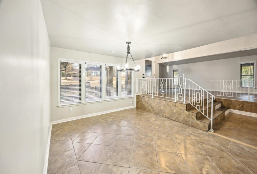 Unfurnished dining room room featuring tile patterned floors and a notable chandelier