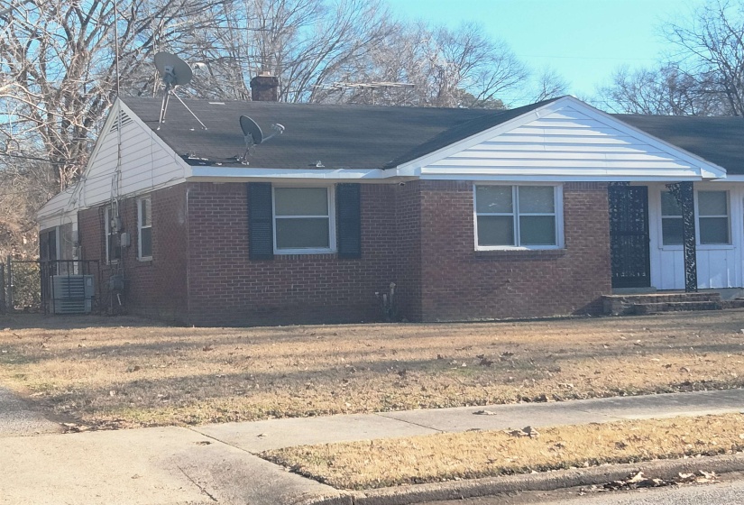 View of front of home featuring brick siding and a chimney