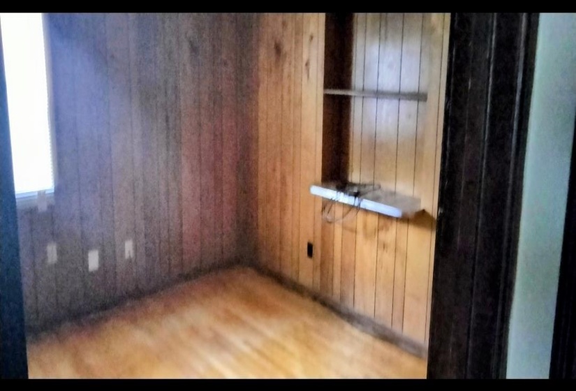 Spare room featuring wooden walls and wood finished floors
