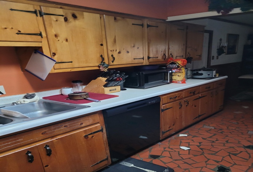Kitchen with light countertops, black appliances, and wood finish cabinets