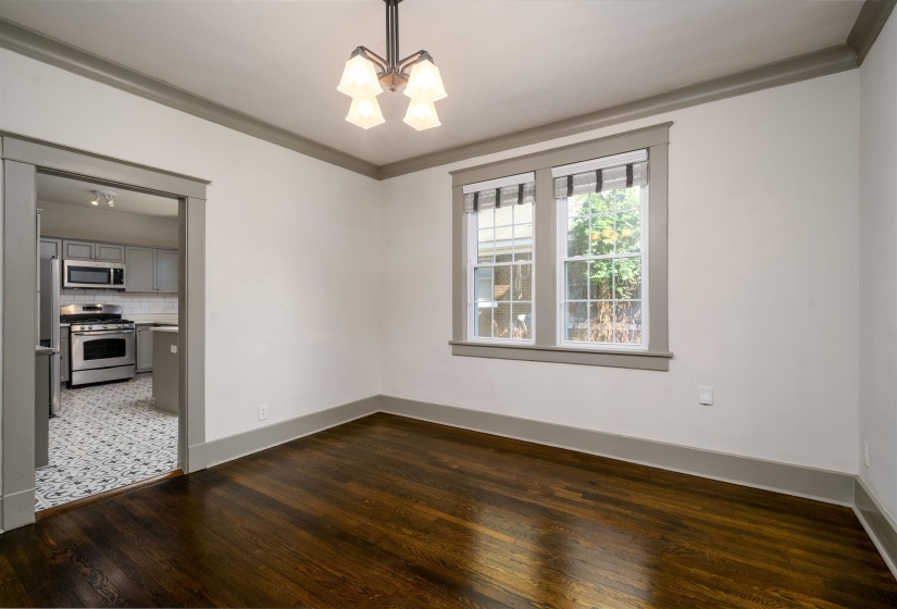 Unfurnished dining area with ornamental molding, dark wood-type flooring, and a chandelier