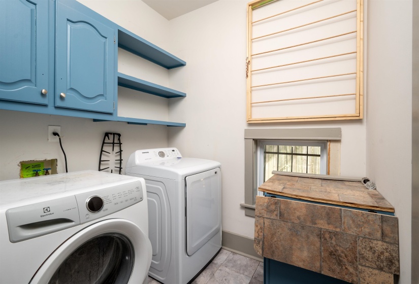 Washroom with cabinet space and washing machine and clothes dryer