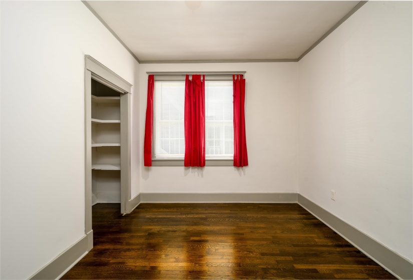 Empty room featuring dark wood-type flooring and ornamental molding