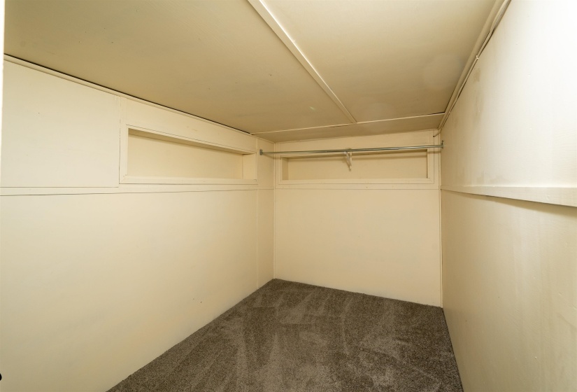 Walk in closet featuring dark colored carpet
