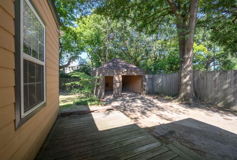 Deck with a patio, an outbuilding, and a fenced backyard