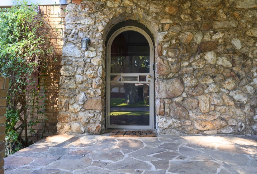 Entrance to property featuring stone siding