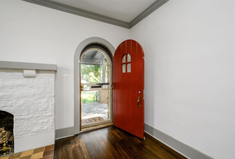 Foyer with dark wood-style floors and crown molding