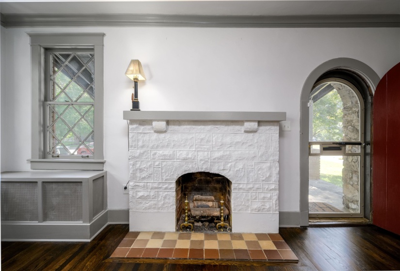 Unfurnished living room with dark wood-type flooring, ornamental molding, and a fireplace with flush hearth